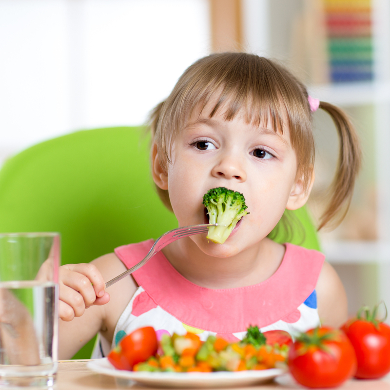 little girl eating vegetables