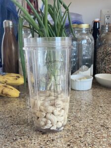 Now the cashews are done soaking. They really swell up and get soft. Put them into a smoothie cup and barely cover with water